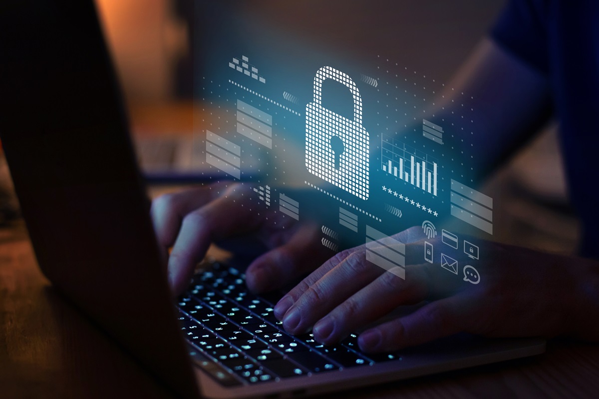 Hands typing on a laptop keyboard with a digital padlock icon and security-related graphics overlaid.